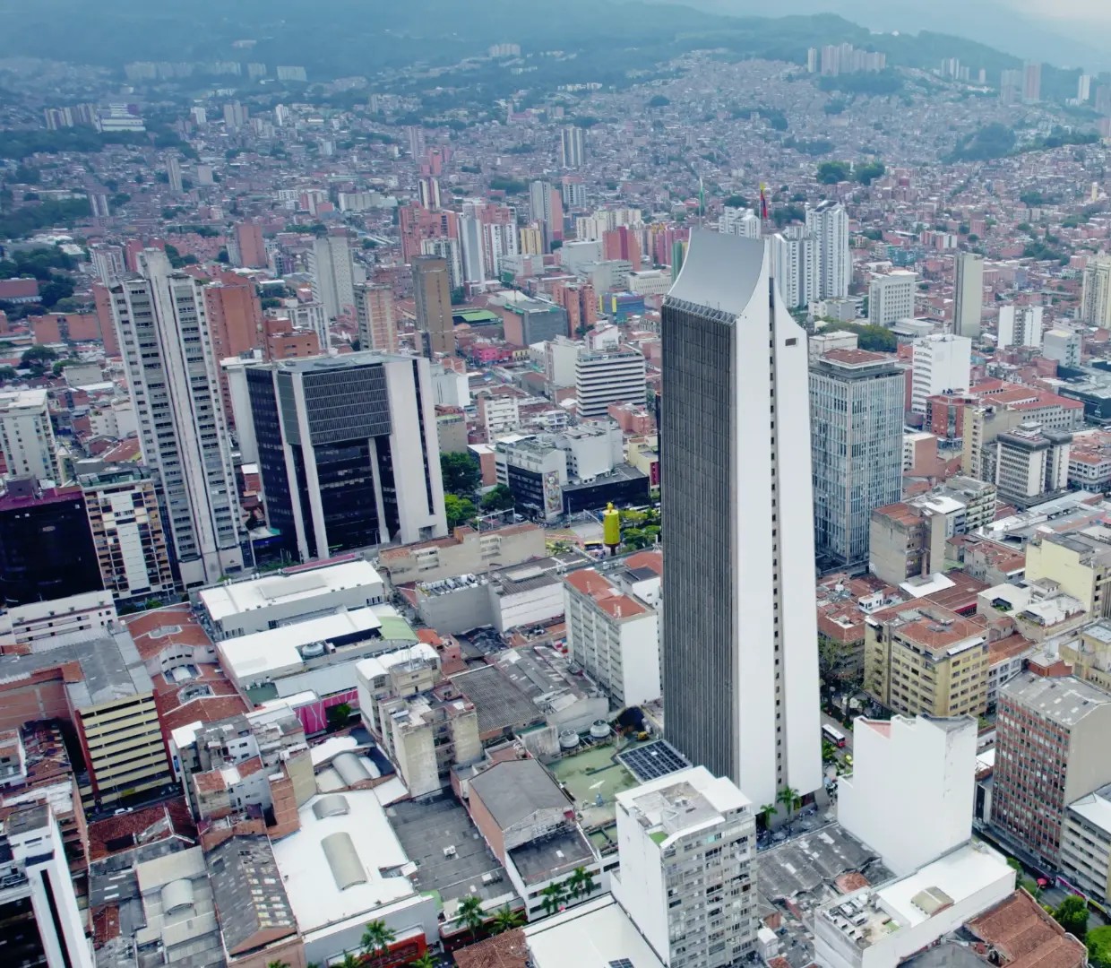 Vista aérea del centro de Medellín con el Edificio Coltejer y las montañas al fondo